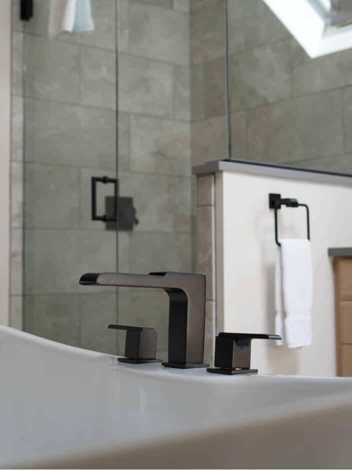 A modern bathroom featuring a glass shower door and a sink.