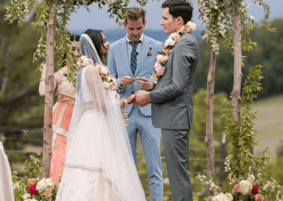 Newlyweds exchanging vows in a romantic outdoor ceremony surrounded by flowers.