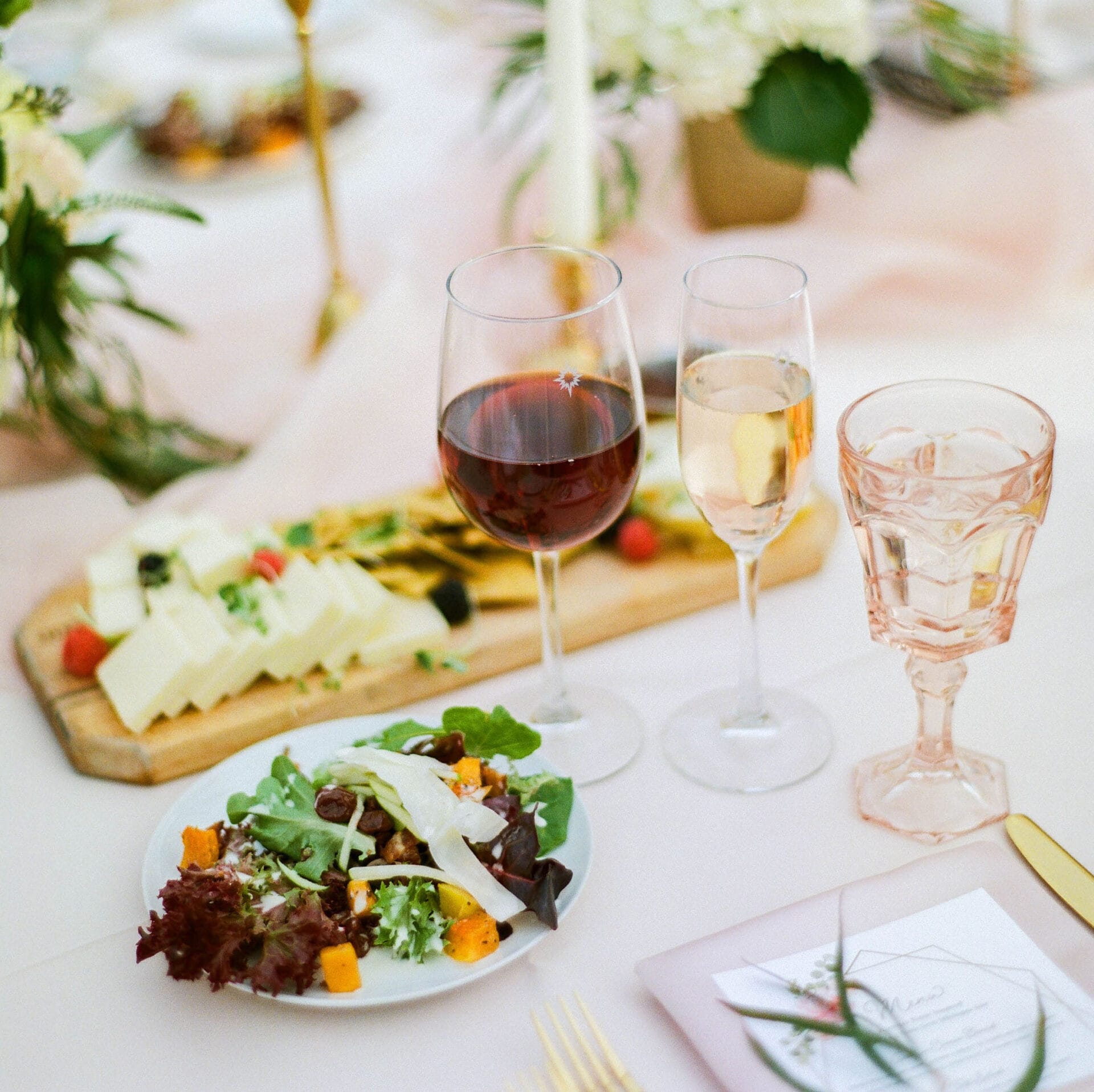 Weddings 64 A group of people sitting at a long table with wine glasses, enjoying a social gathering.