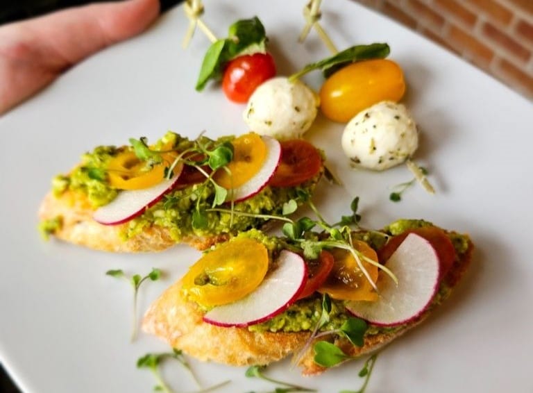 A white plate displaying a sunny-side-up egg accompanied by a vibrant mix of assorted vegetables.
